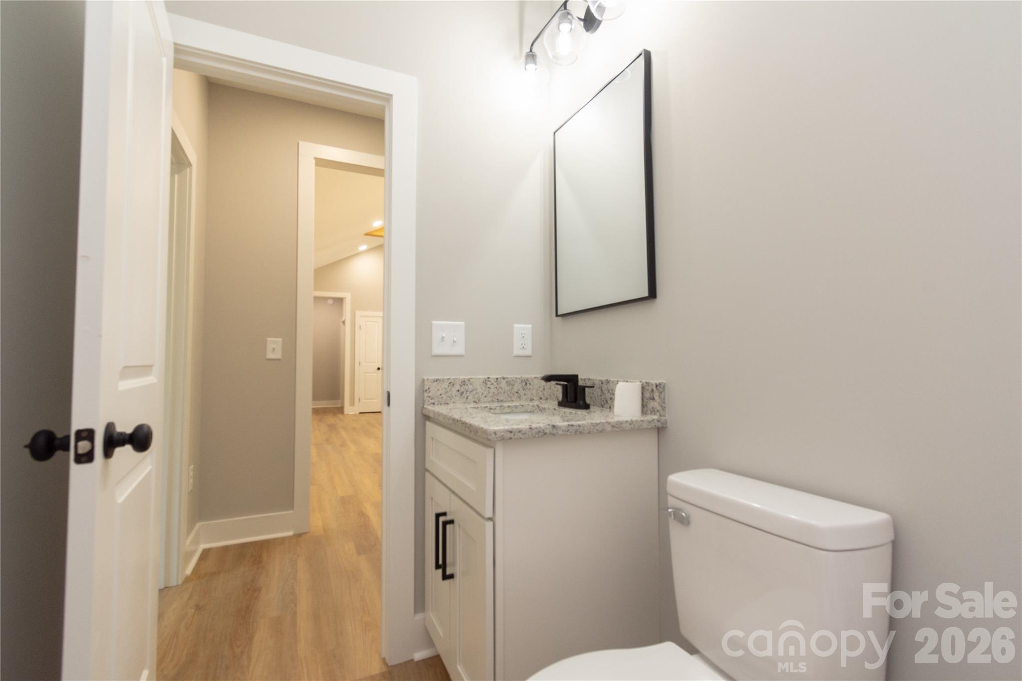 472 Oak Road Norwood, NC 28128 - Photo 15 of 27 a bathroom with a granite countertop toilet sink and mirror