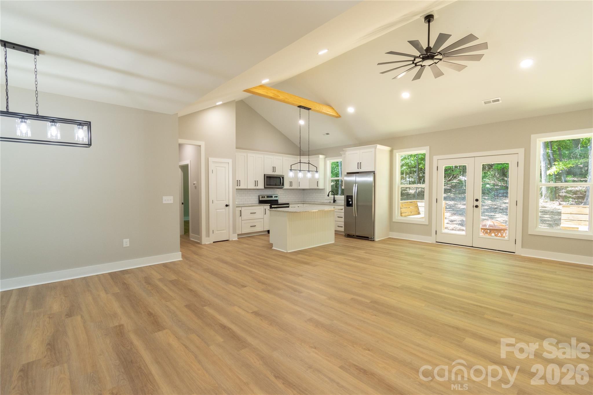 472 Oak Road Norwood, NC 28128 - Photo 3 of 27 a view of a kitchen with a stove cabinets a ceiling fan and wooden floor