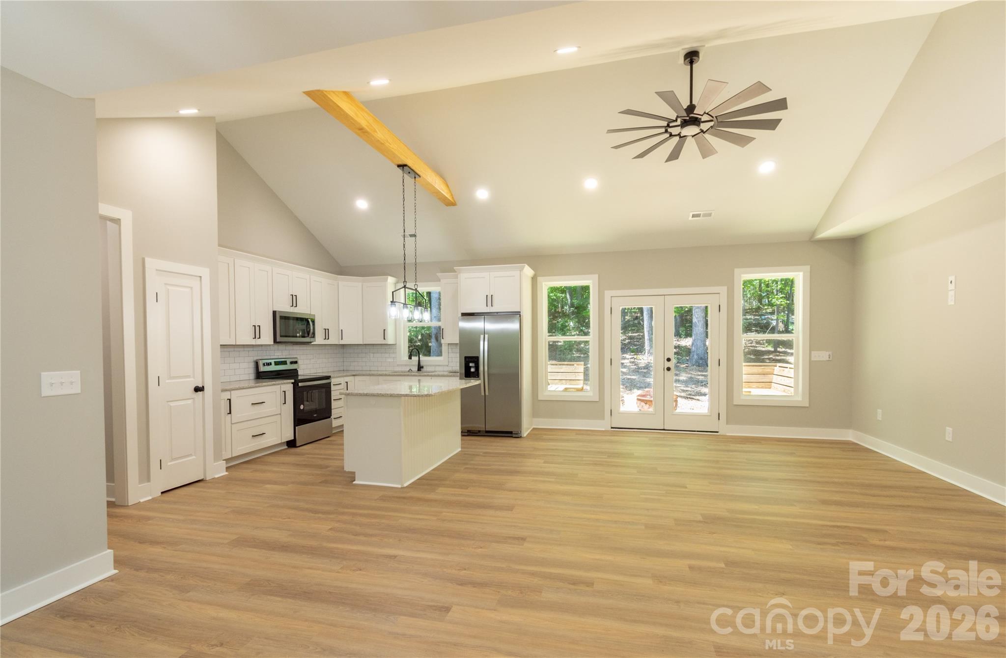 472 Oak Road Norwood, NC 28128 - Photo 4 of 27 a view of a kitchen with a stove cabinets a ceiling fan and wooden floor