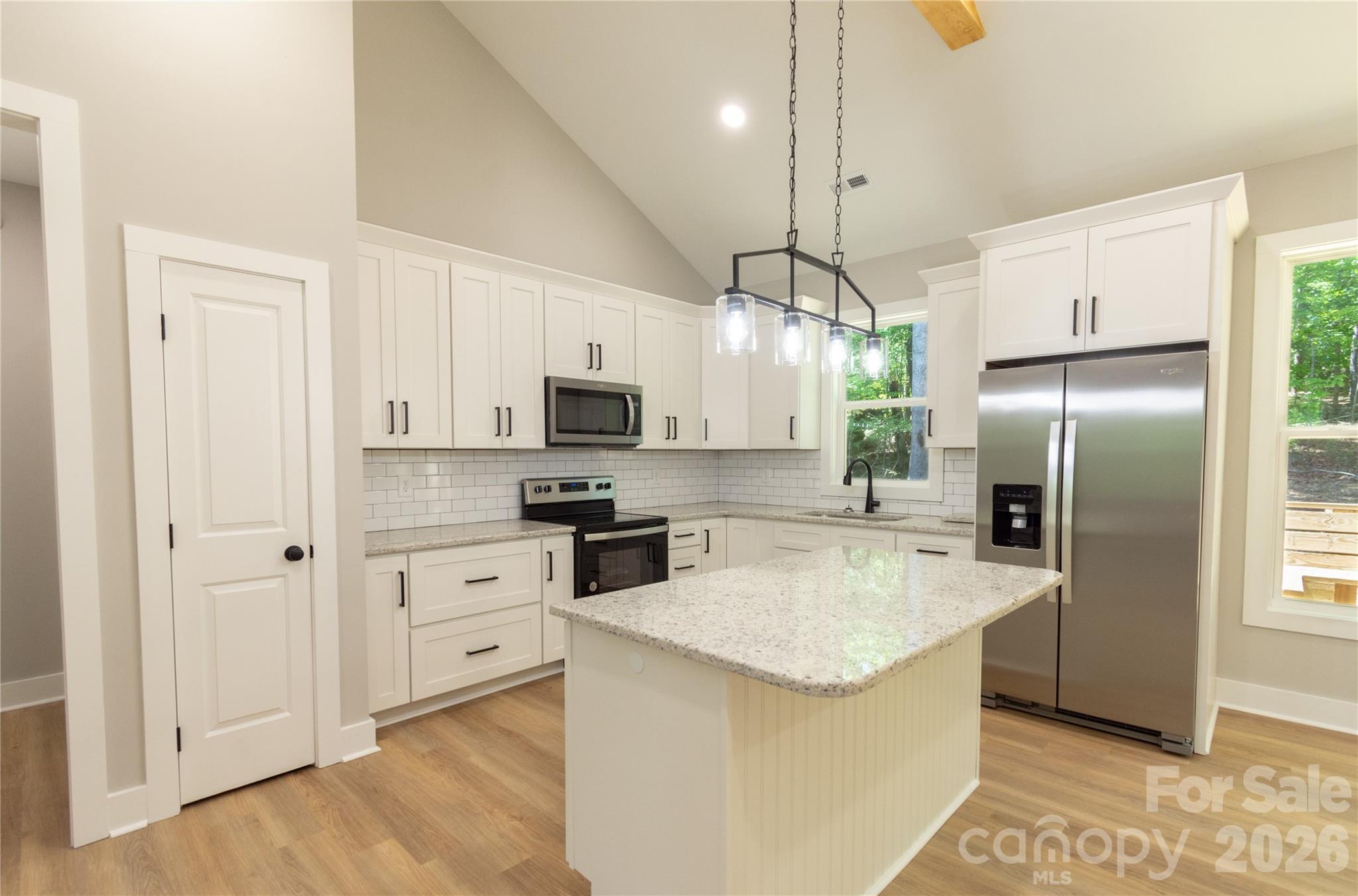 472 Oak Road Norwood, NC 28128 - Photo 6 of 27 a kitchen with stainless steel appliances granite countertop a refrigerator a stove a sink and white cabinets