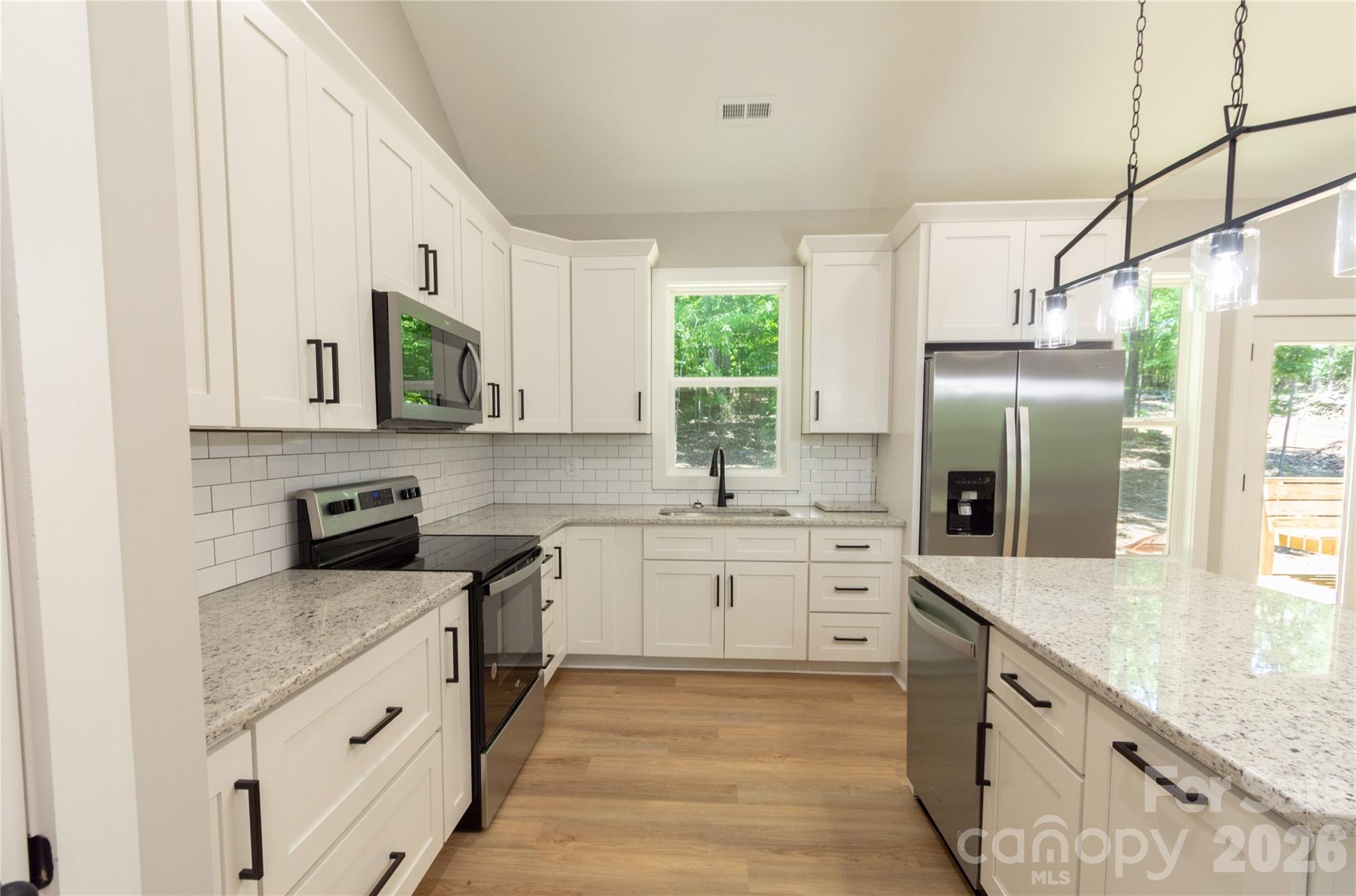 472 Oak Road Norwood, NC 28128 - Photo 7 of 27 a kitchen with granite countertop a sink stainless steel appliances and cabinets