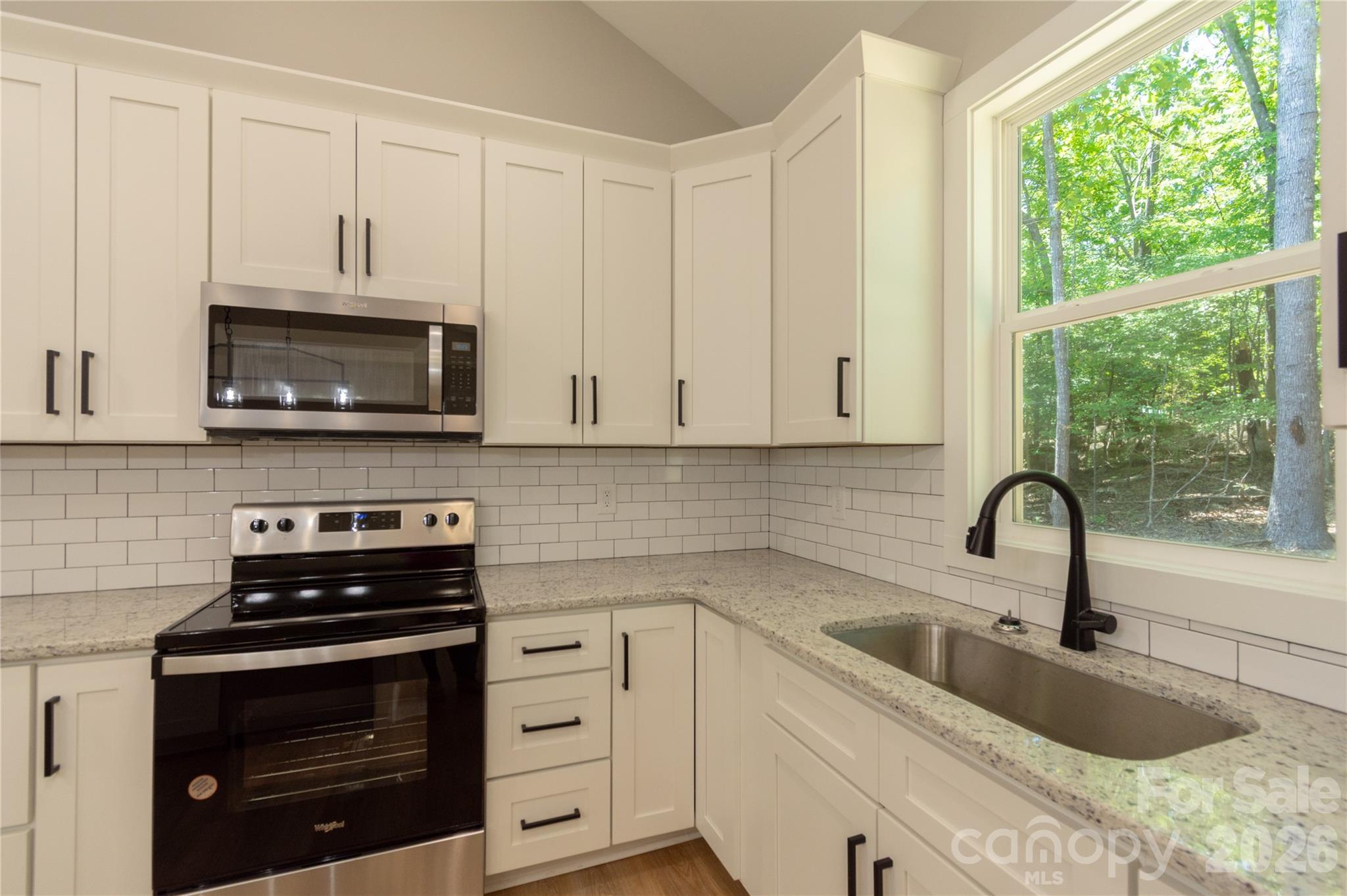 472 Oak Road Norwood, NC 28128 - Photo 9 of 27 a kitchen with granite countertop a sink stainless steel appliances and cabinets
