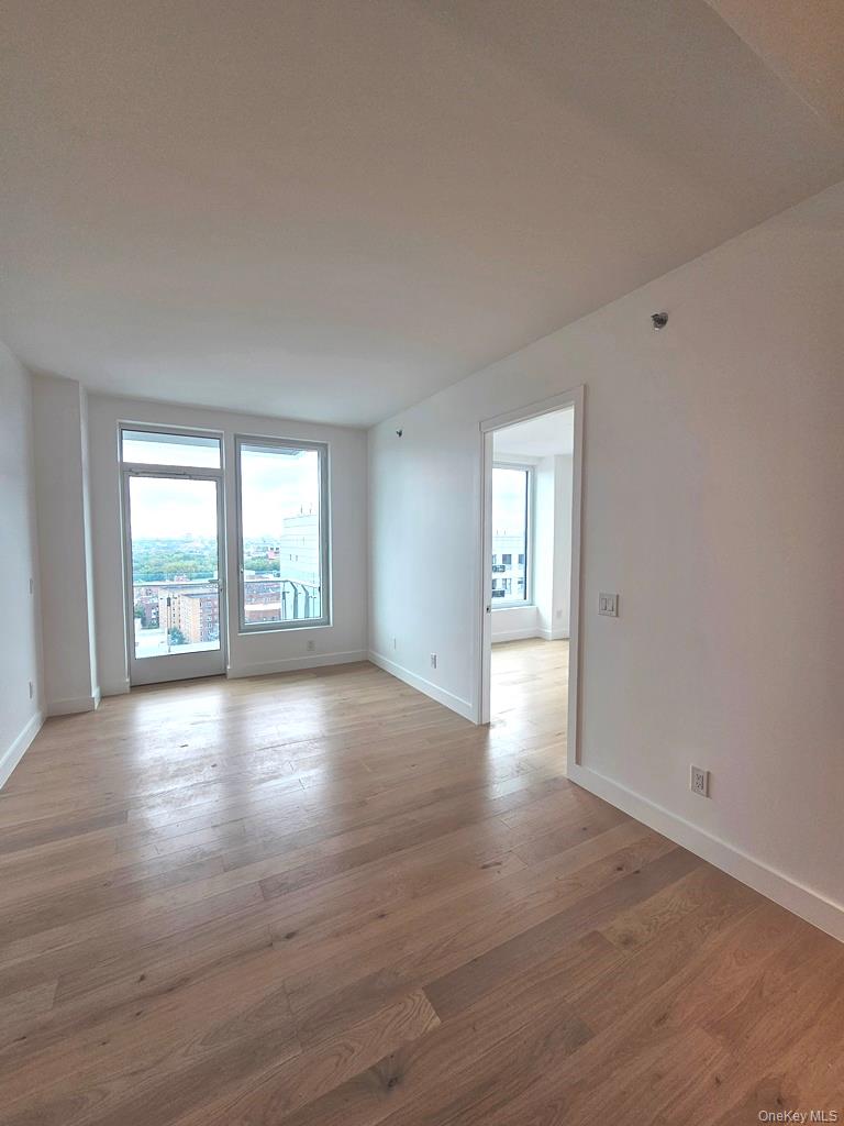 136-18 Maple Avenue, Unit 16A Queens, NY 11355 - Photo 14 of 15 wooden floor in an empty room with a window