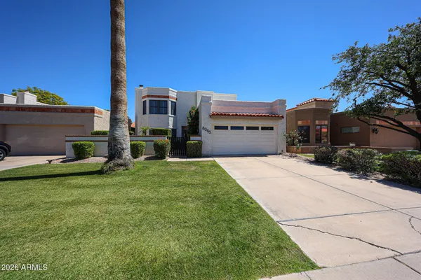 a front view of a house with a garden and yard