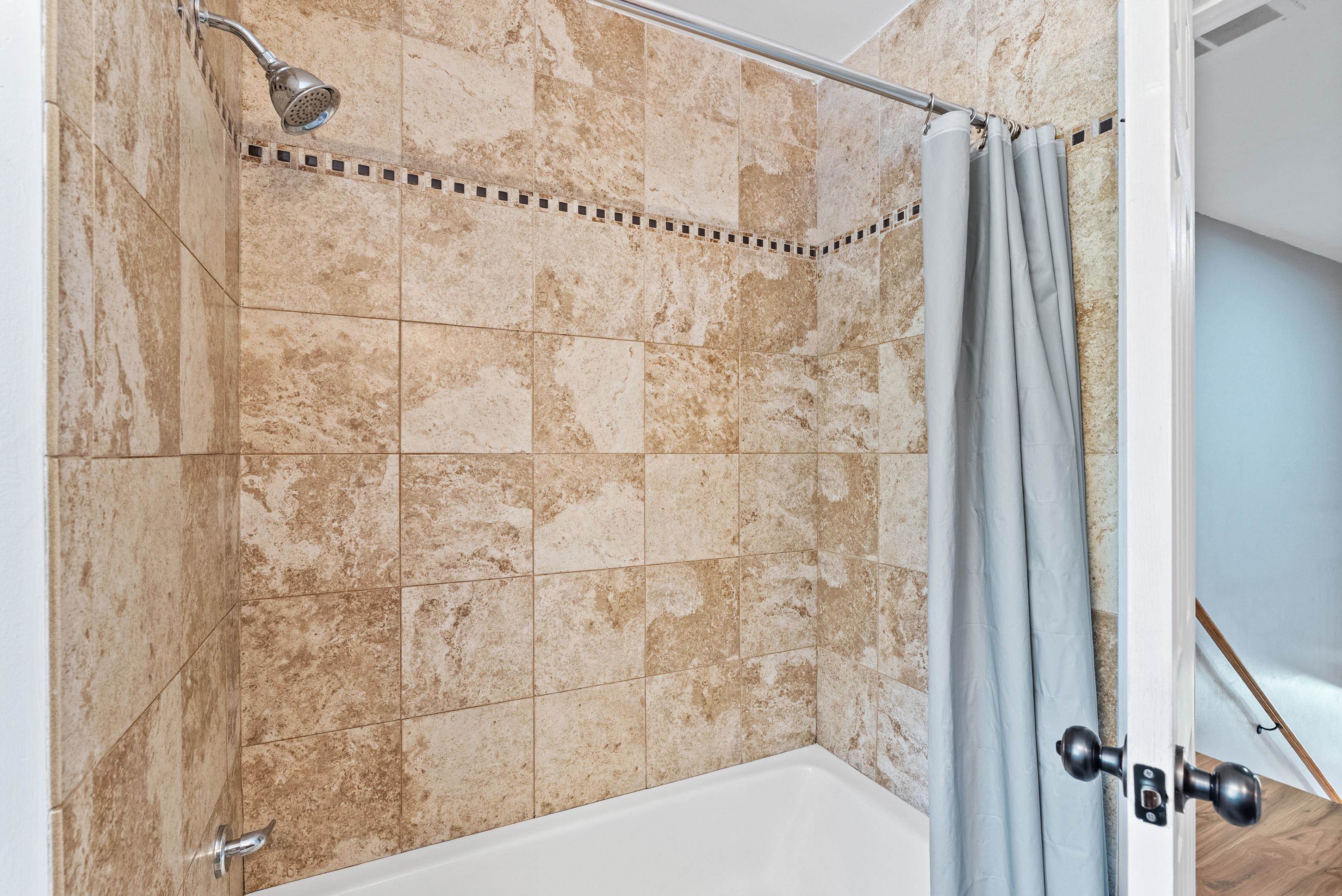 779 Strickland Road Coldwater, MS 38618 - Photo 25 of 40 Bathtub with tiled surround featuring a decorative mosaic accent and a chrome shower head