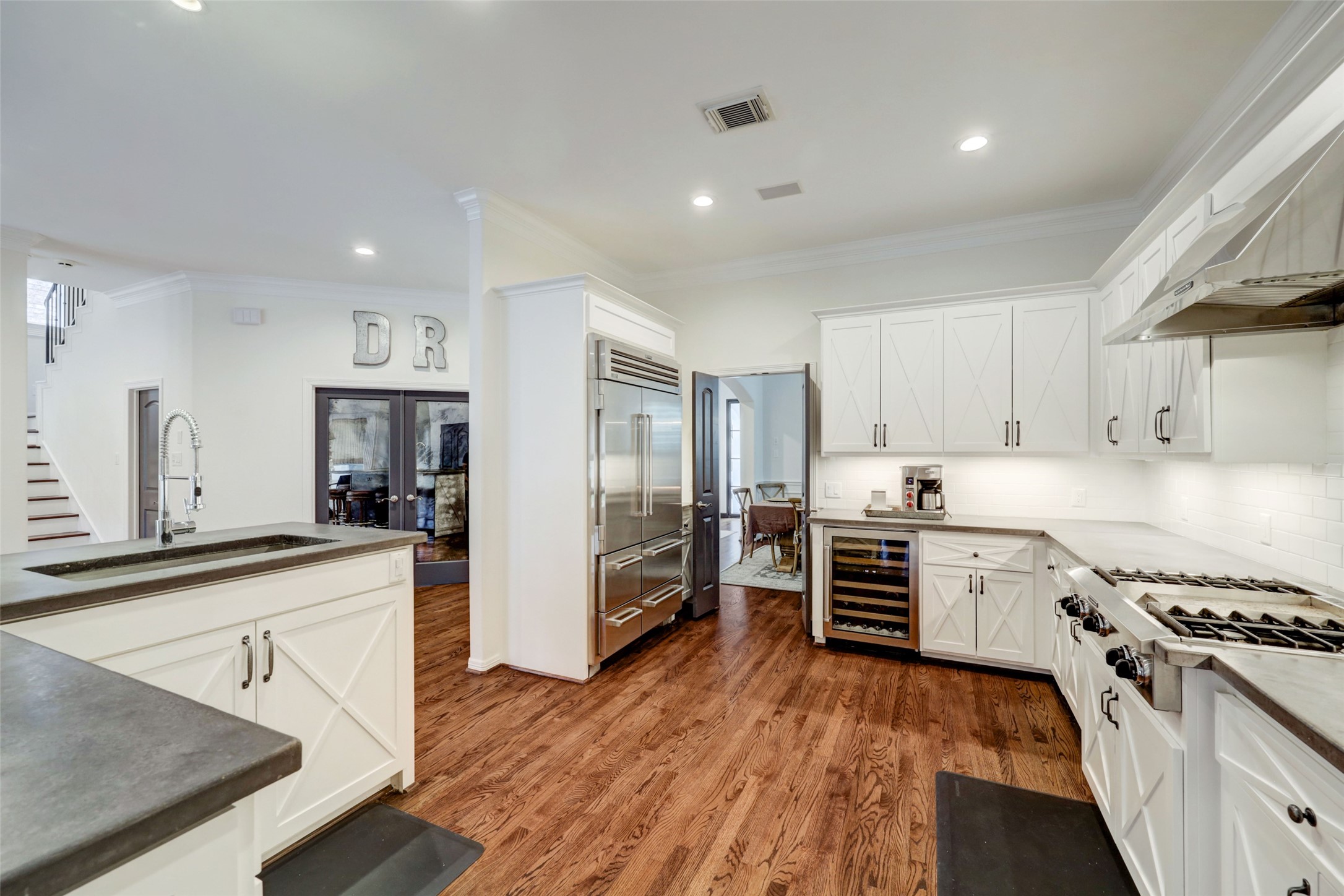 4004 Childress Street Houston, TX 77005 - Photo 19 of 34 a large kitchen with cabinets wooden floor and stainless steel appliances