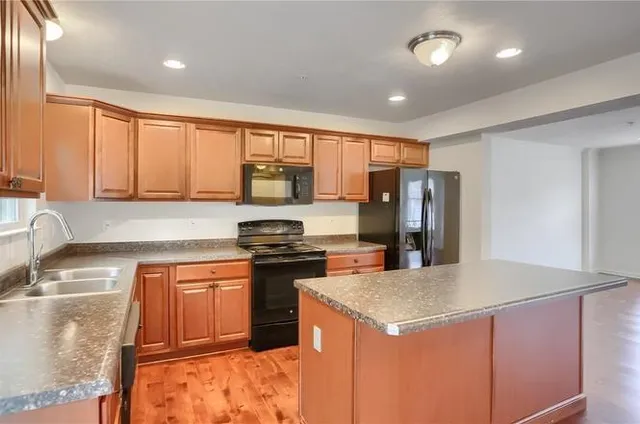 a kitchen with stainless steel appliances granite countertop a sink stove and refrigerator