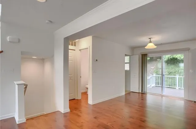 an empty room with wooden floor and a window