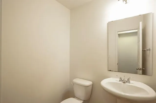 a bathroom with a sink a toilet and mirror
