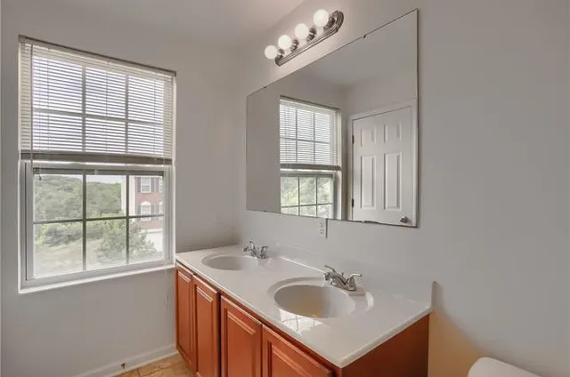 a bathroom with a sink a vanity and a window