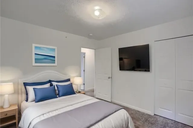 a bedroom with a bed and a flat screen tv