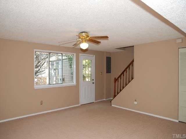 7735 Sandra Lane Raleigh, NC 27615 - Photo 2 of 8 Neutral carpet, designer neutral wall paint, ceiling fan with light, triple window, closet, 9-light door to deck