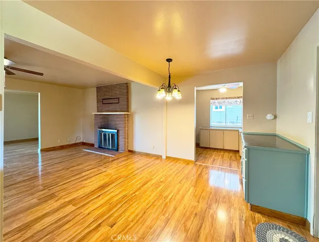 a view of a big room with wooden floor and windows