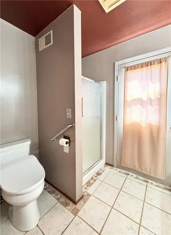 a bathroom with a toilet and a shower