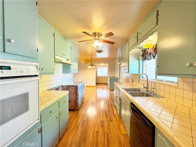 a large kitchen with stainless steel appliances granite countertop a sink and cabinets
