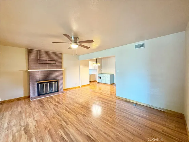 a living room with stainless steel appliances kitchen island granite countertop furniture and a wooden floor