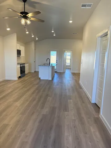 a view of a livingroom with hardwood floor and a ceiling fan
