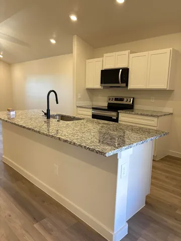 a kitchen with sink a microwave and cabinets