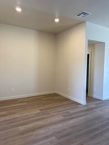 a view of an empty room with wooden floor