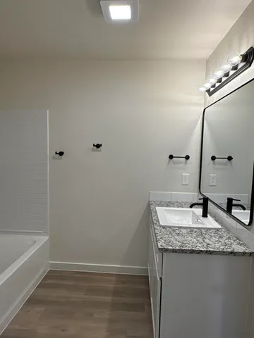 a bathroom with a granite countertop sink and a mirror