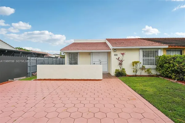 a view of a house with backyard and a garden