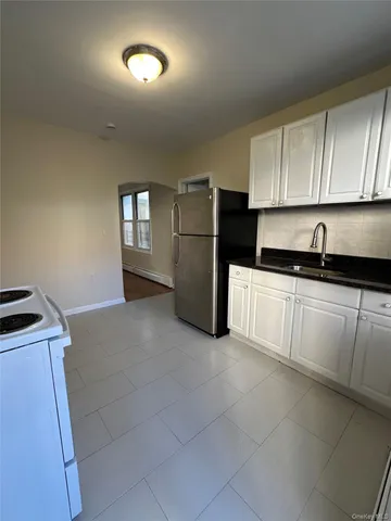 a kitchen with a sink a refrigerator and cabinets