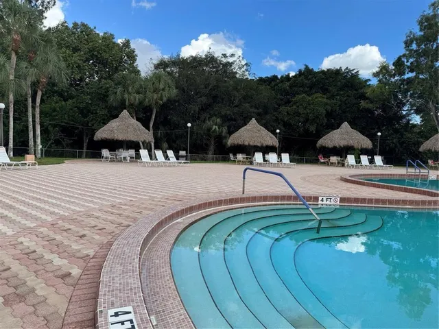 a swimming pool with an outdoor space and seating area
