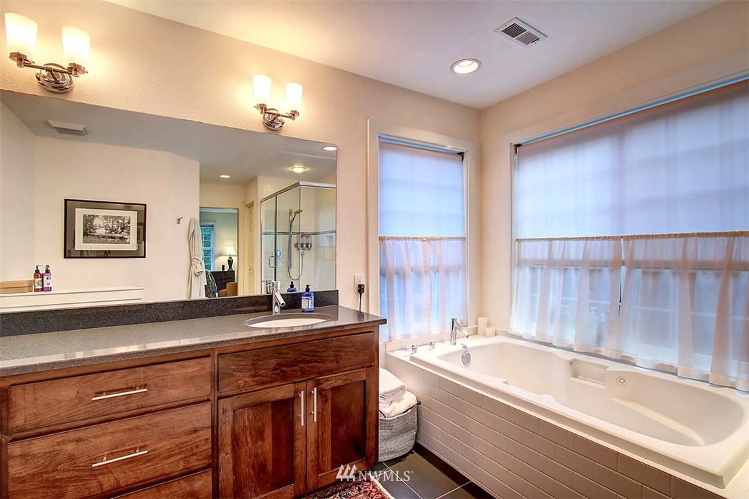 6615 Cultus Bay Road Clinton, WA 98236 - Photo 13 of 25 a bathroom with a bathtub a double vanity sink and mirror
