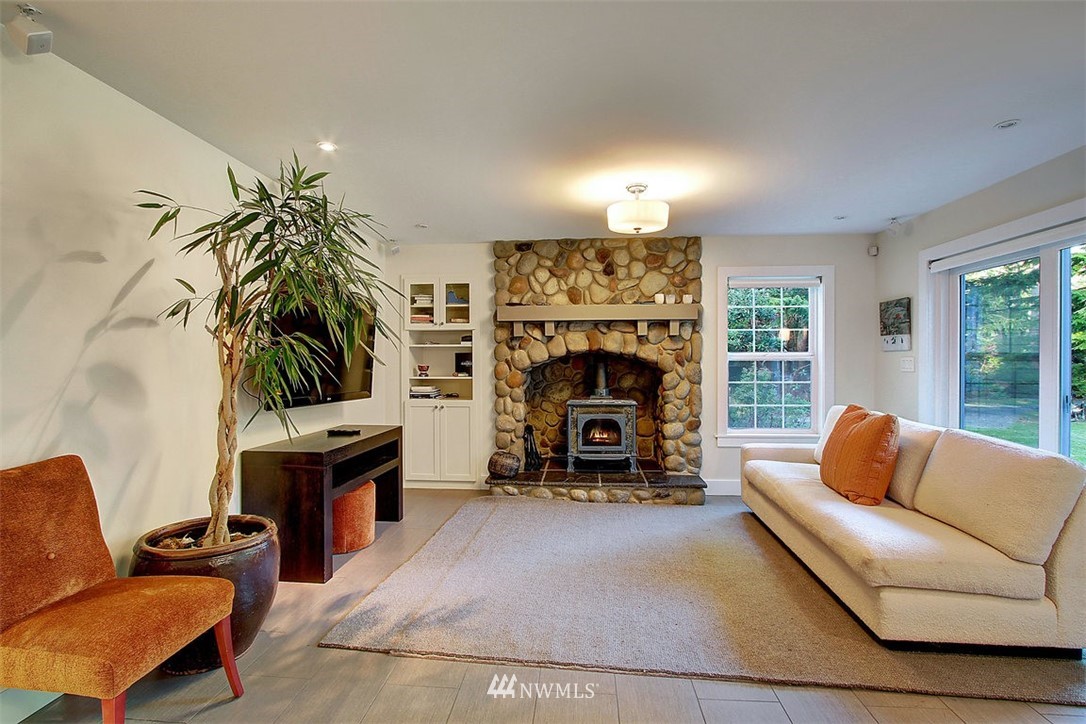 6615 Cultus Bay Road Clinton, WA 98236 - Photo 5 of 25 a living room with furniture a fireplace and a flat screen tv