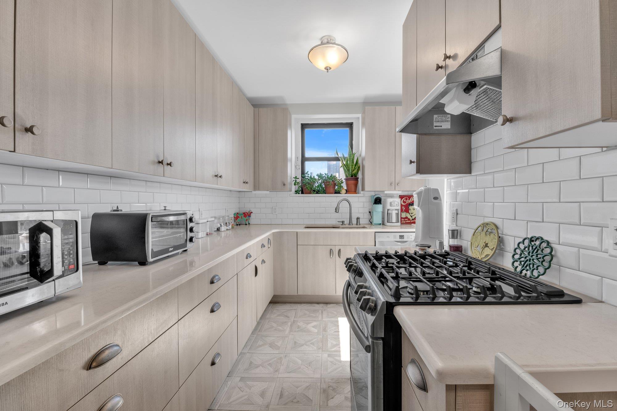 84-51 Beverly Road, Unit 6A Queens, NY 11415 - Photo 6 of 14 a kitchen with a sink a stove and cabinets