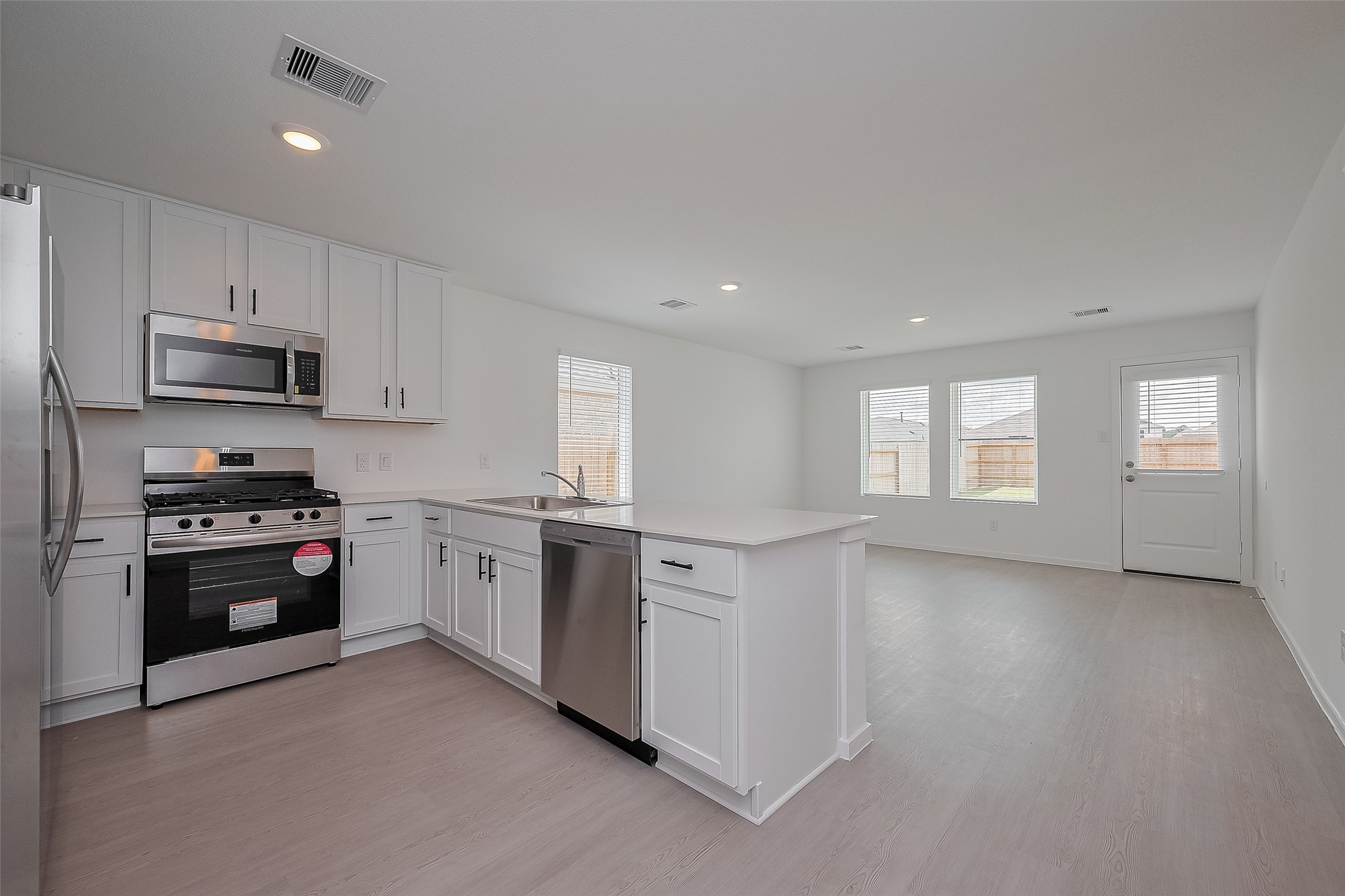 21459 Montecagnano Avenue New Caney, TX 77357 - Photo 11 of 27 a kitchen with stainless steel appliances granite countertop a stove a sink and a refrigerator