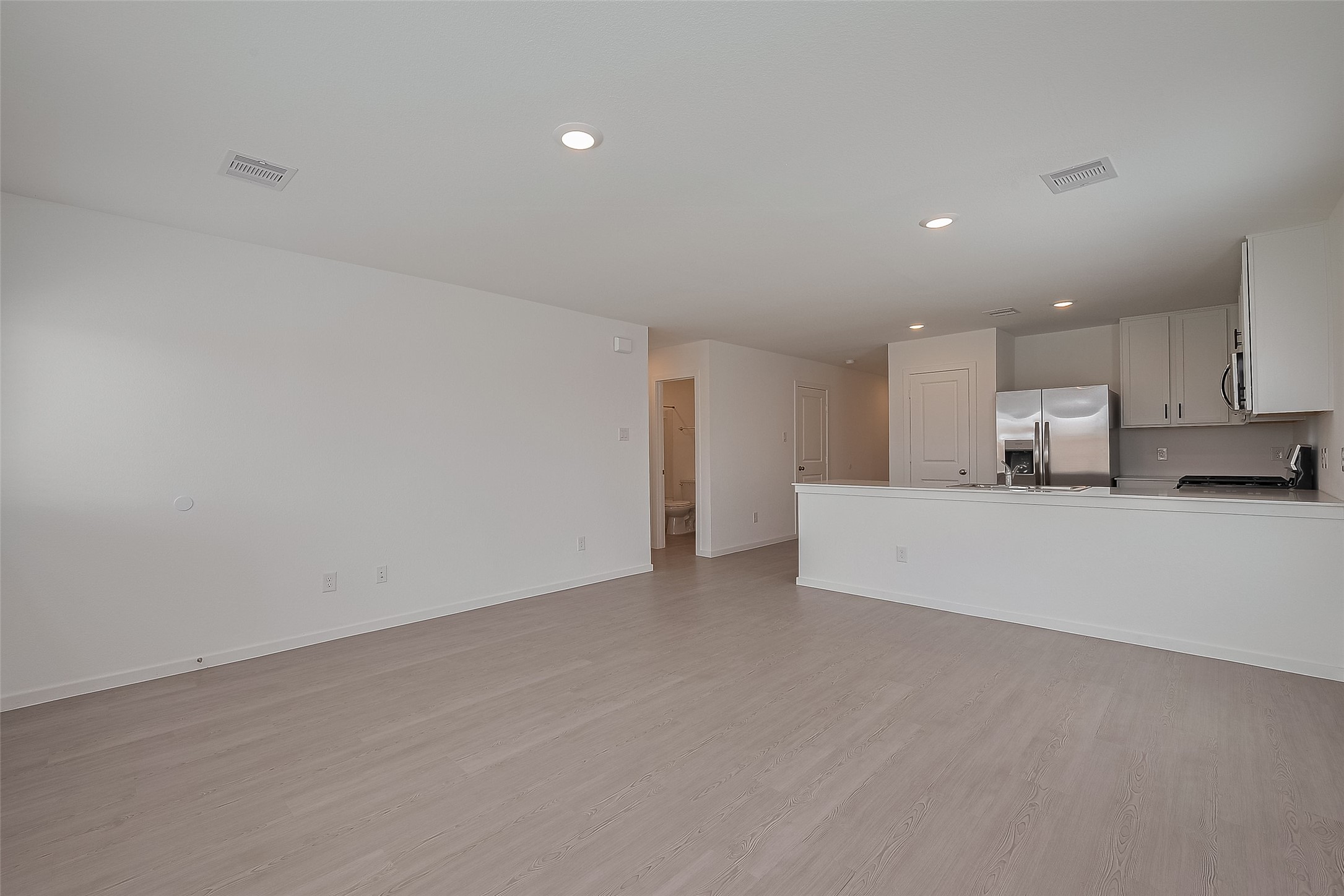 21459 Montecagnano Avenue New Caney, TX 77357 - Photo 9 of 27 a view of kitchen with kitchen island white cabinets and wooden floor
