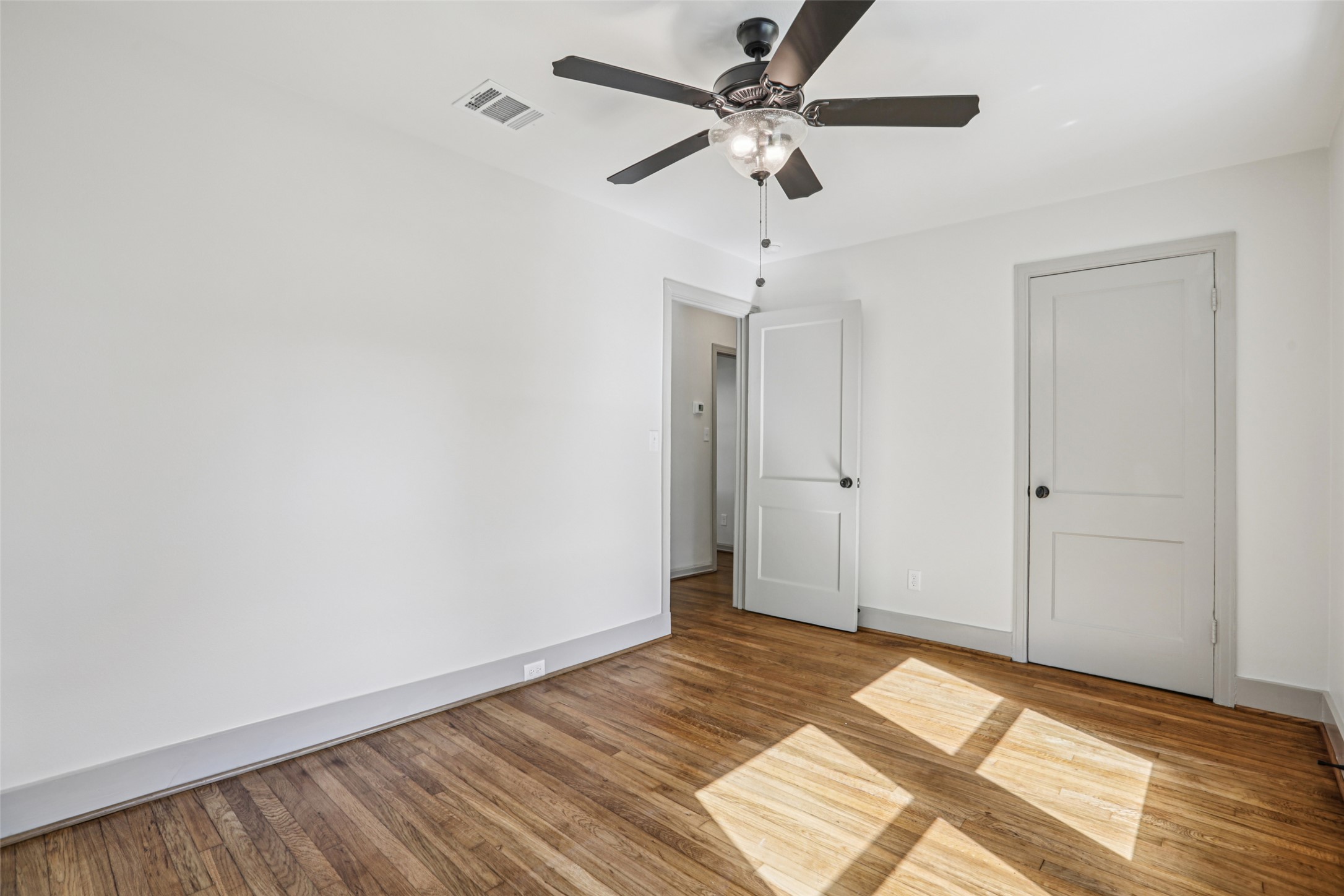 602 Short Street Smithville, TX 78957 - Photo 8 of 27 a view of a room with wooden floor and a ceiling fan