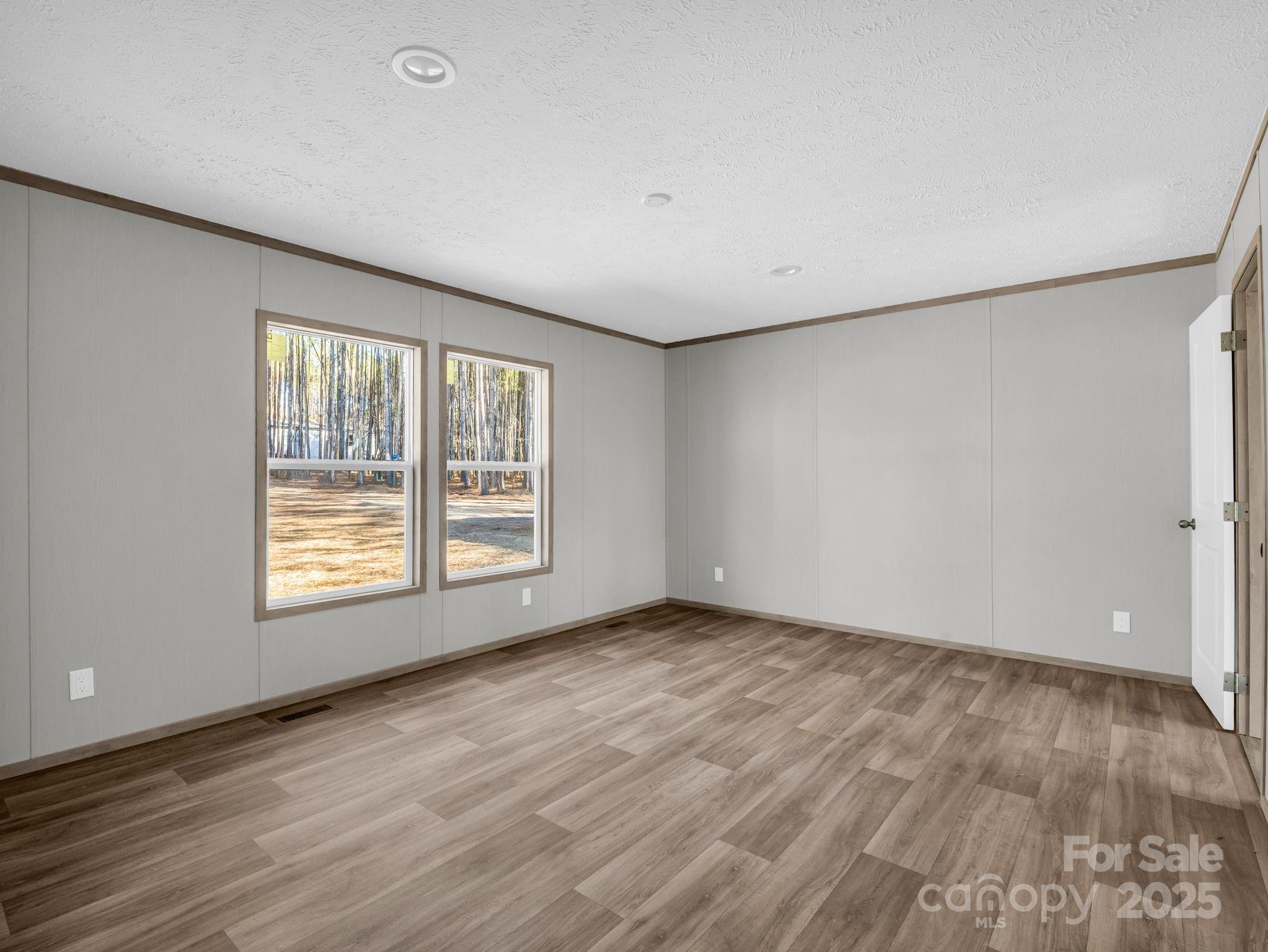 844 Tiney Road Ellenboro, NC 28040 - Photo 14 of 45 an empty room with wooden floor and windows