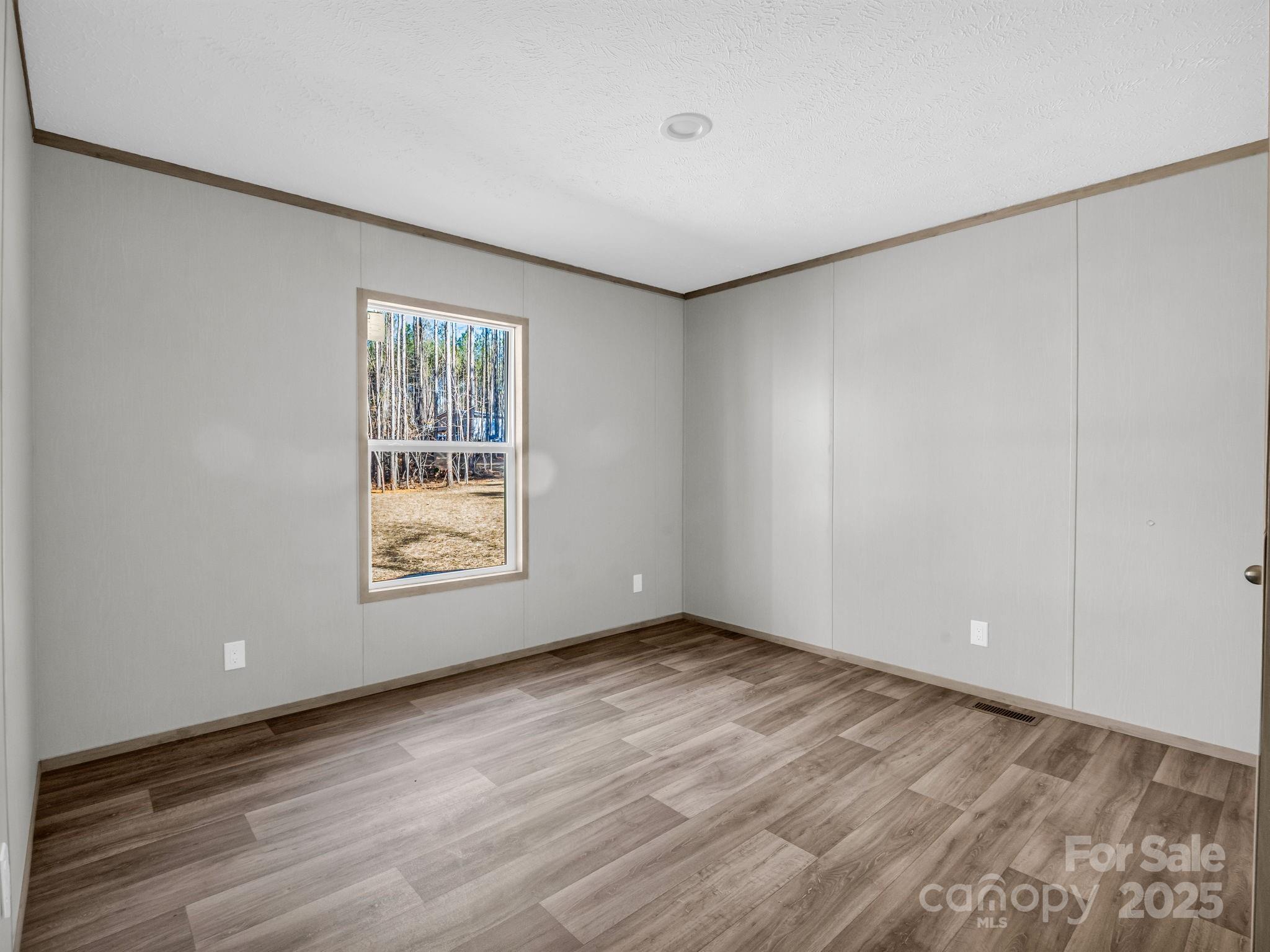 844 Tiney Road Ellenboro, NC 28040 - Photo 23 of 45 a view of an empty room with wooden floor and a window