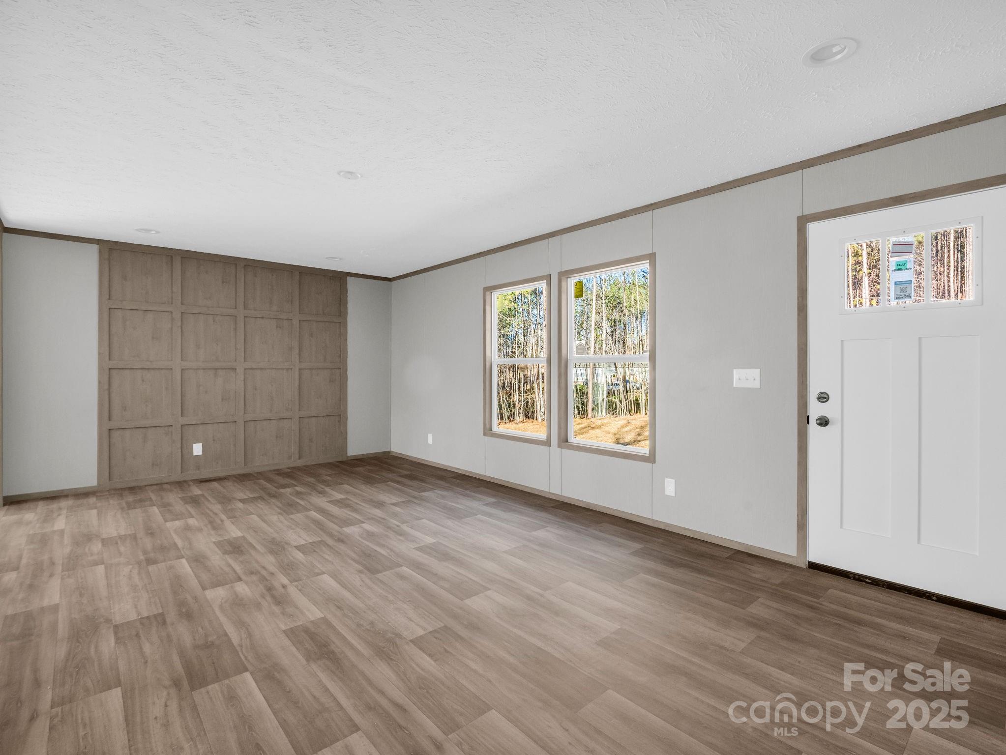 844 Tiney Road Ellenboro, NC 28040 - Photo 5 of 45 a view of an empty room with wooden floor and a window