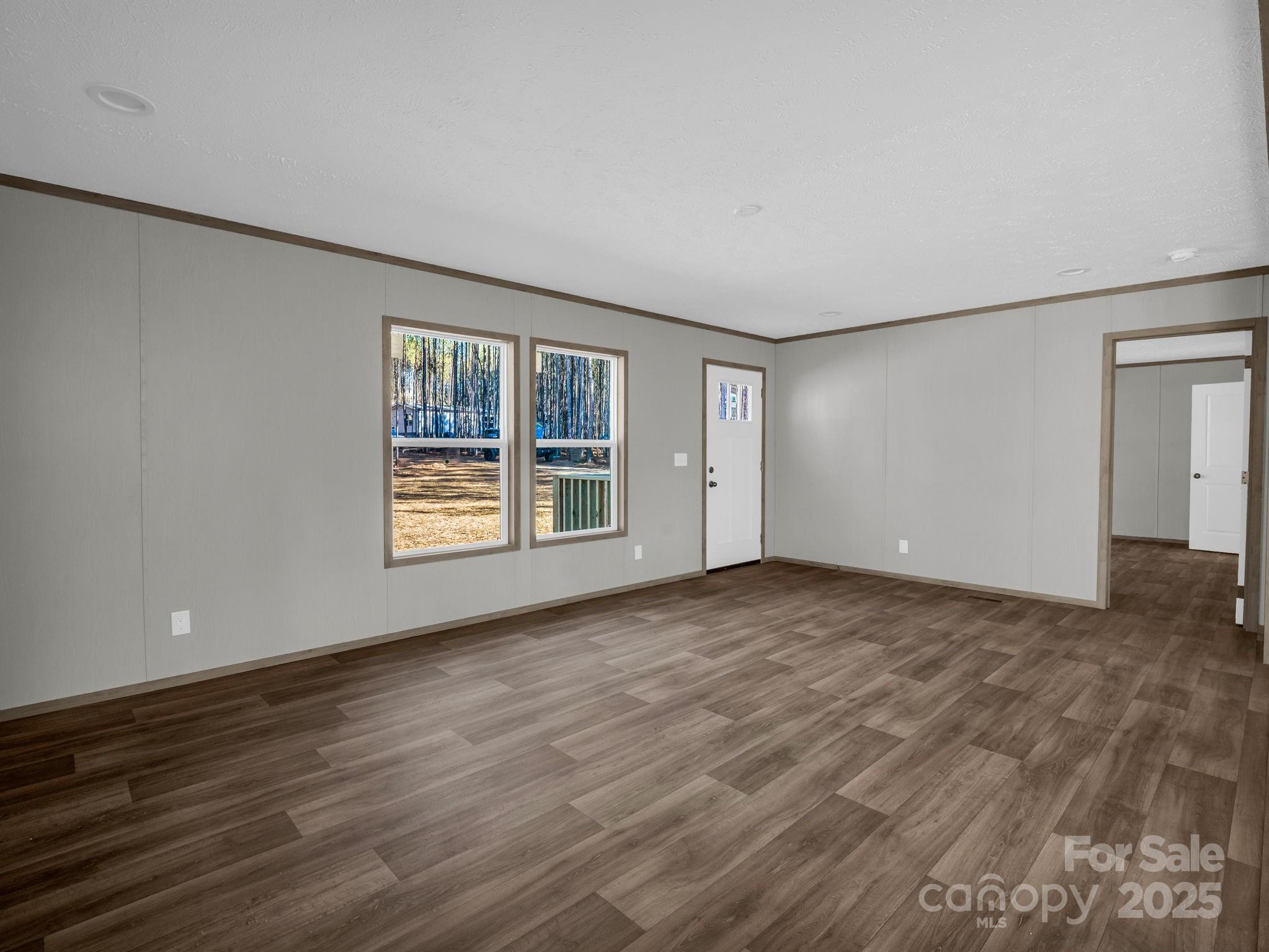 844 Tiney Road Ellenboro, NC 28040 - Photo 6 of 45 a view of an empty room with wooden floor and a window