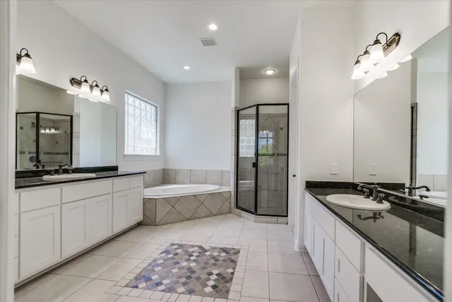 a large bathroom with a granite countertop sink a toilet a mirror and shower