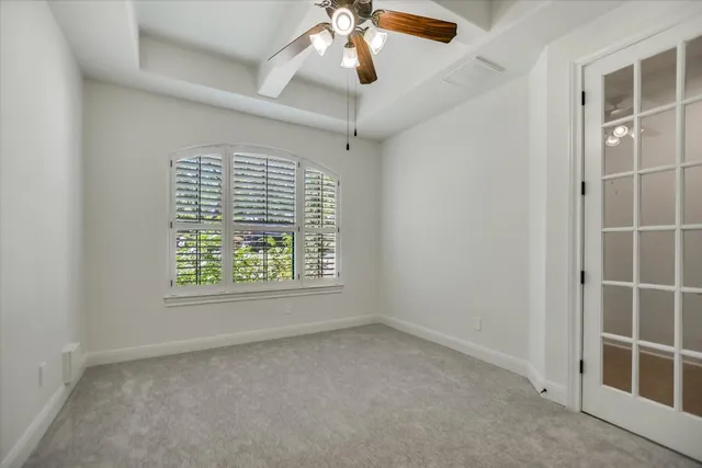 an empty room with a window and a fan