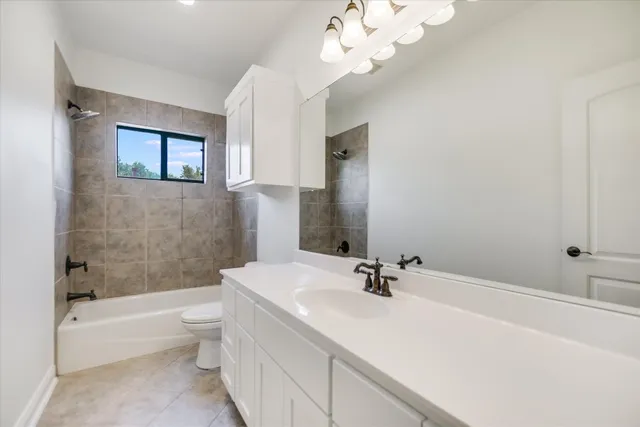 a bathroom with a bathtub a sink and a large mirror