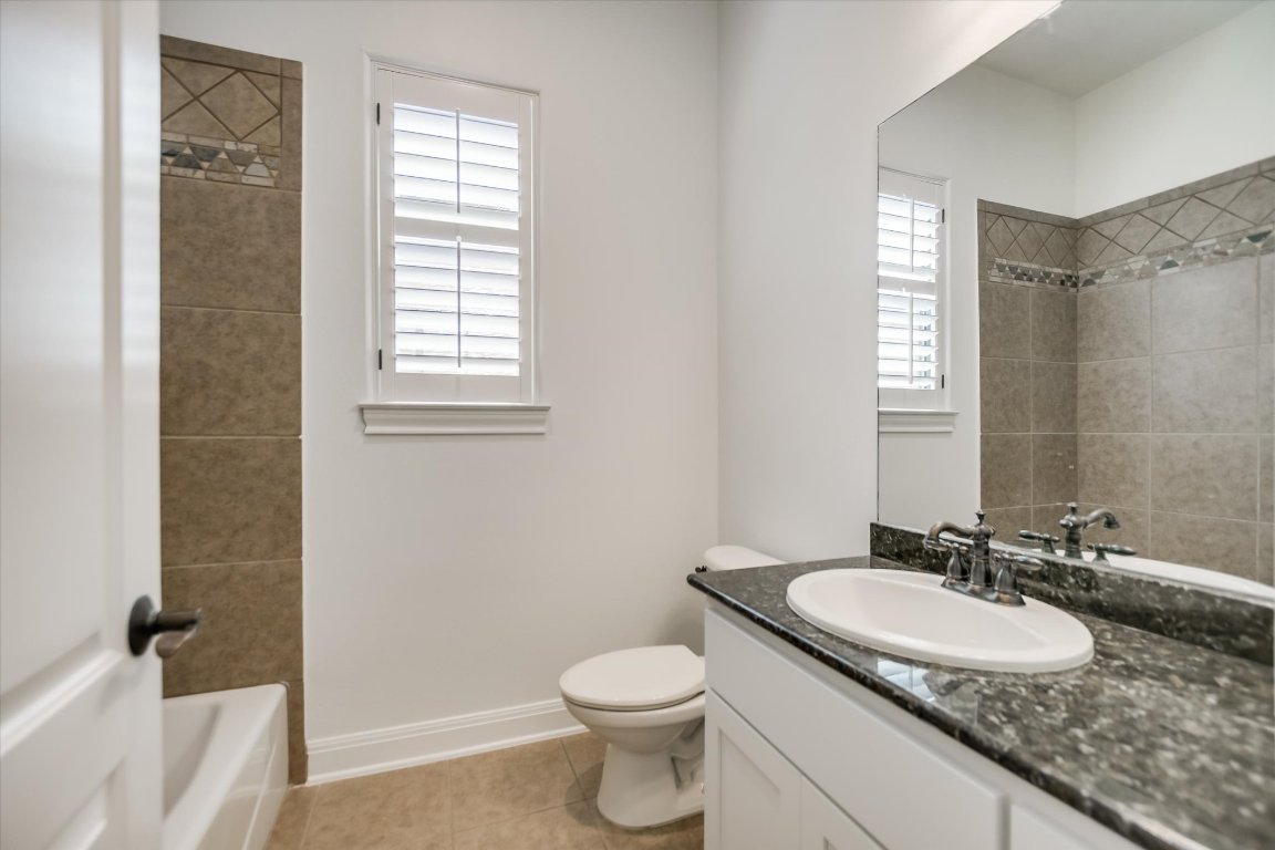 2617 University Club Drive Austin, TX 78732 - Photo 19 of 25 a bathroom with a granite countertop sink toilet and a mirror