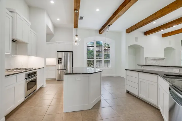 a kitchen with stainless steel appliances granite countertop a stove a sink and a microwave