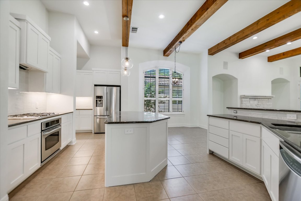 2617 University Club Drive Austin, TX 78732 - Photo 4 of 25 a kitchen with stainless steel appliances granite countertop a stove a sink and a microwave