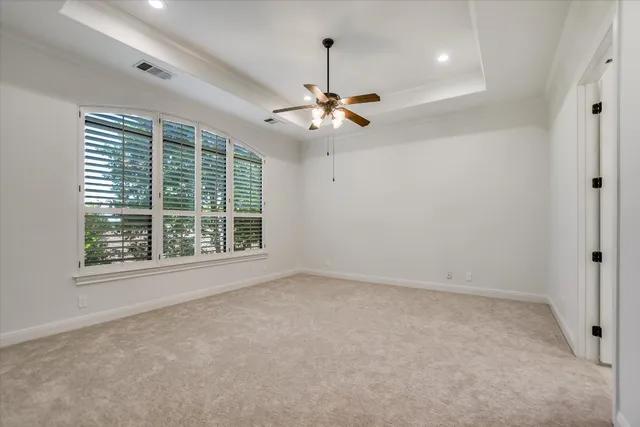 an empty room with a ceiling fan and a window