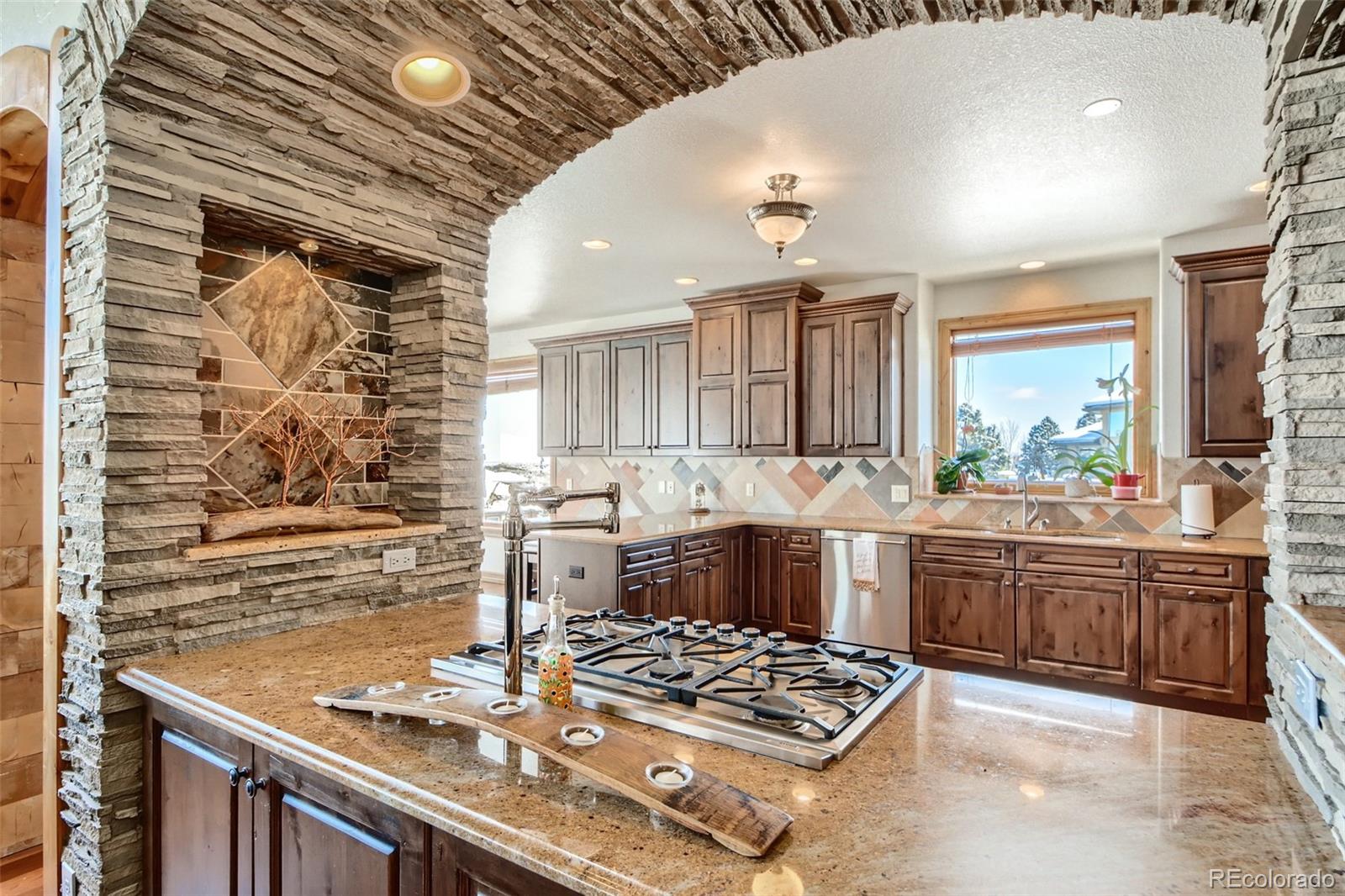 11227 Explorers Run Littleton, CO 80125 - Photo 12 of 33 a kitchen with stainless steel appliances granite countertop a sink stove and cabinets