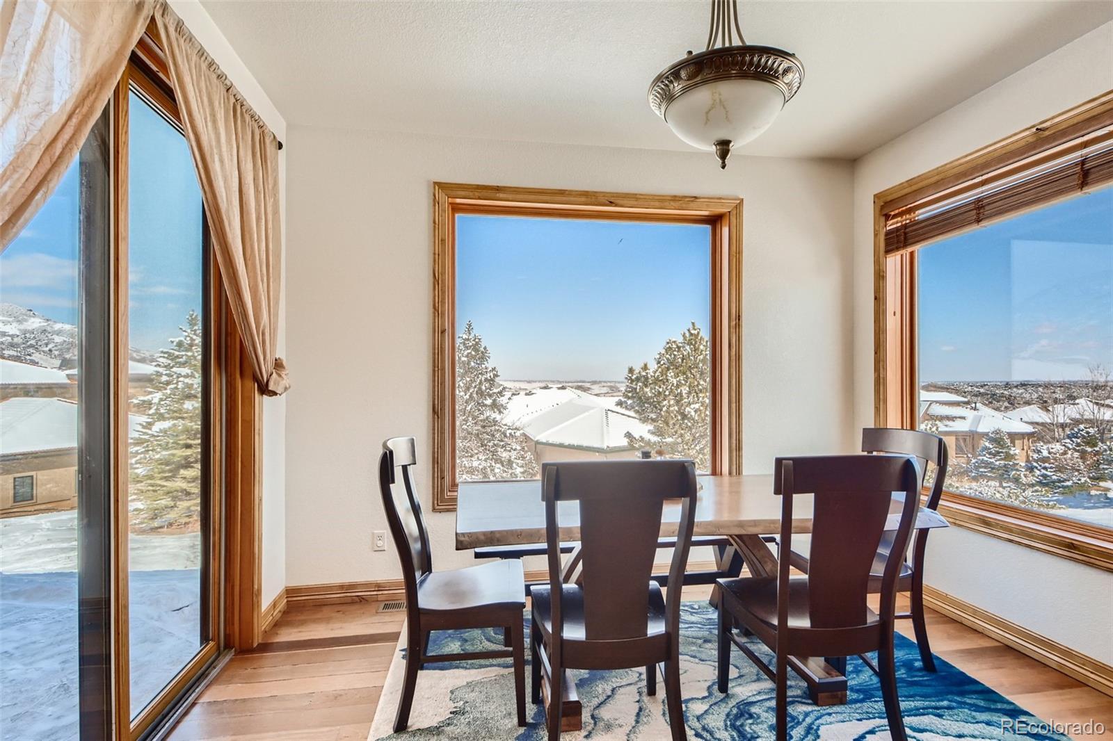 11227 Explorers Run Littleton, CO 80125 - Photo 13 of 33 a view of a dining room with furniture window and wooden floor