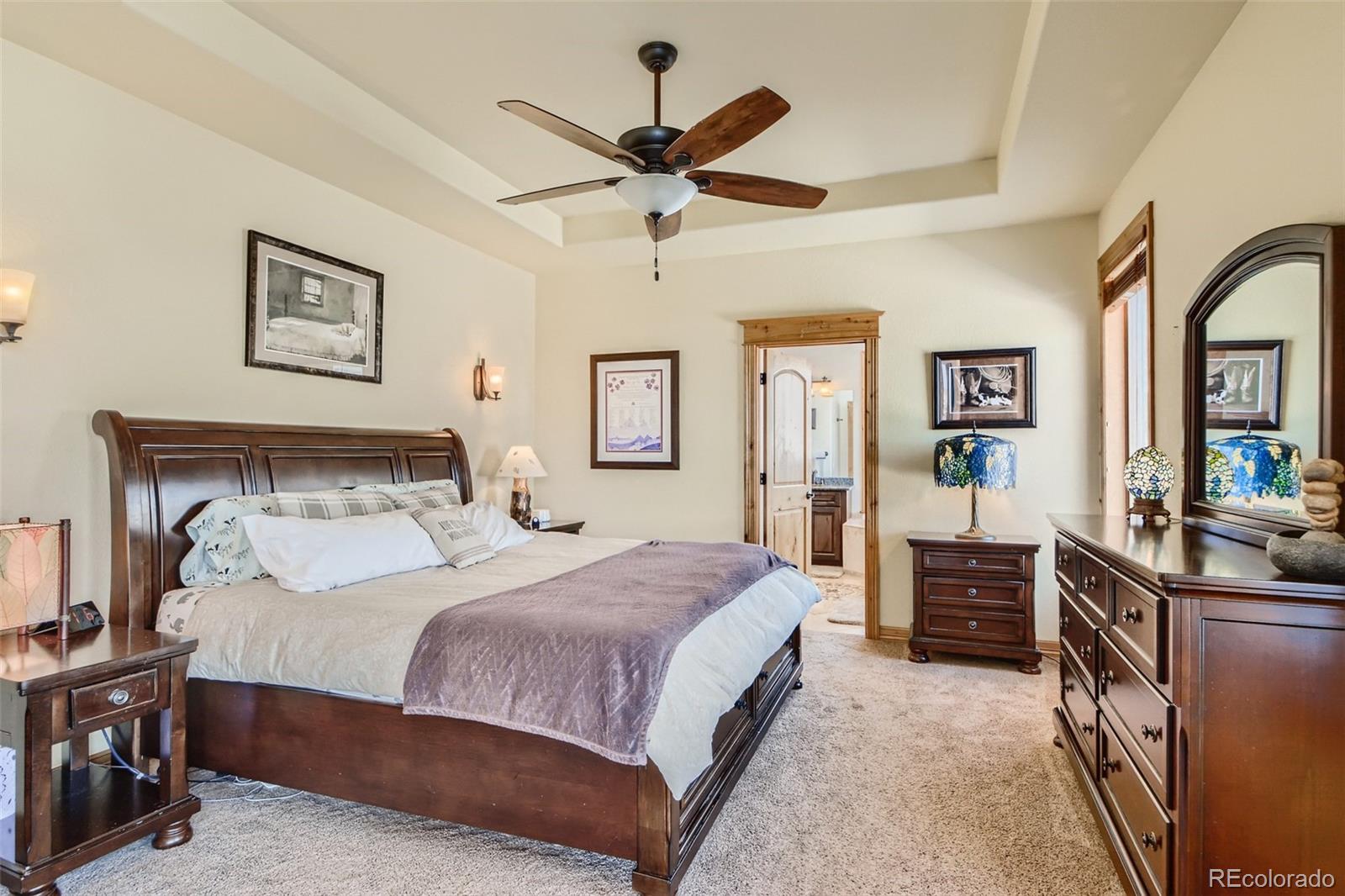11227 Explorers Run Littleton, CO 80125 - Photo 15 of 33 a bedroom with a bed and a chandelier
