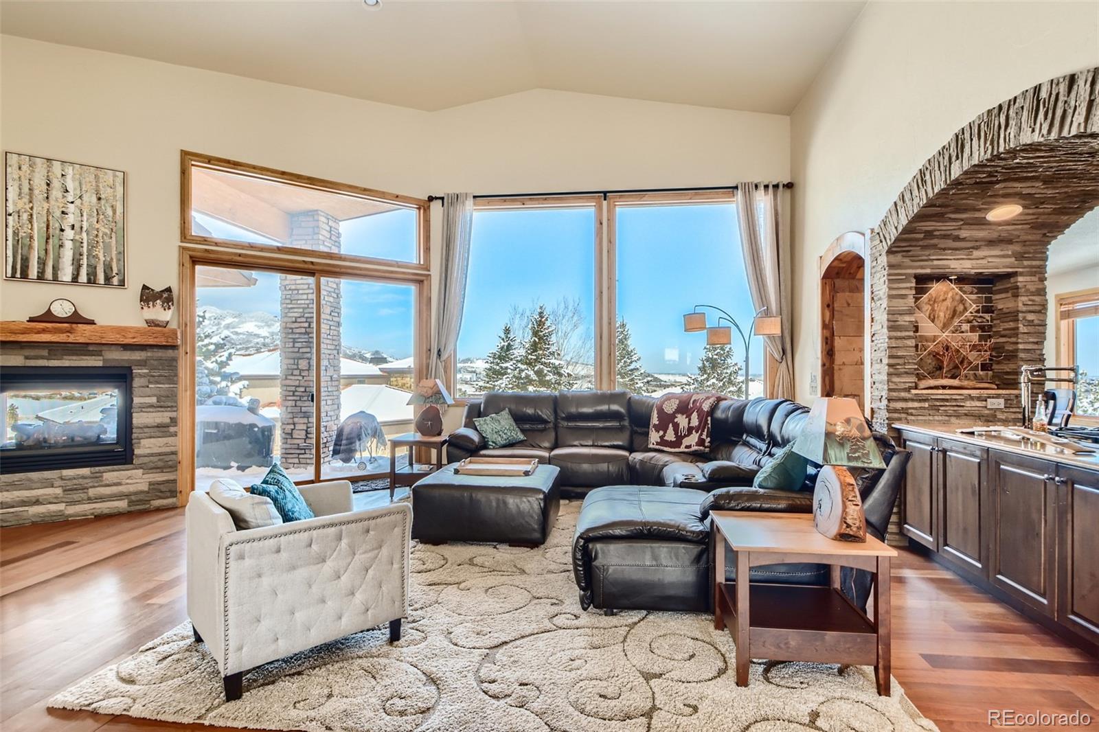 11227 Explorers Run Littleton, CO 80125 - Photo 5 of 33 a living room with furniture large windows and wooden floor