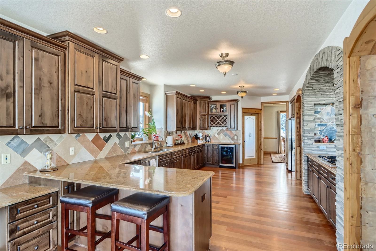 11227 Explorers Run Littleton, CO 80125 - Photo 9 of 33 a living room with stainless steel appliances kitchen island granite countertop furniture and a kitchen view