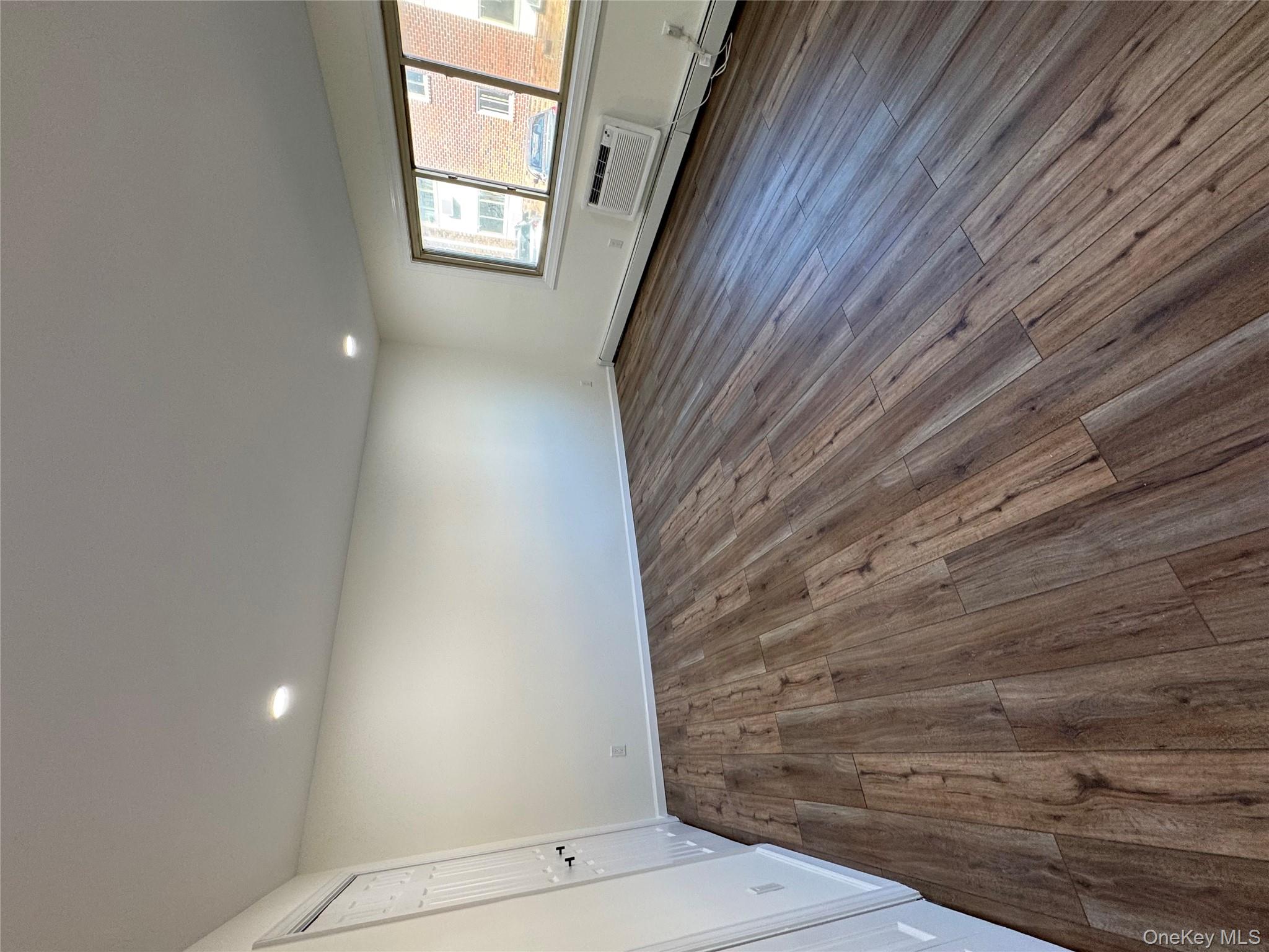 2449 I Union Avenue, Unit 34A Islip, NY 11751 - Photo 11 of 19 an empty room with wooden floor and windows